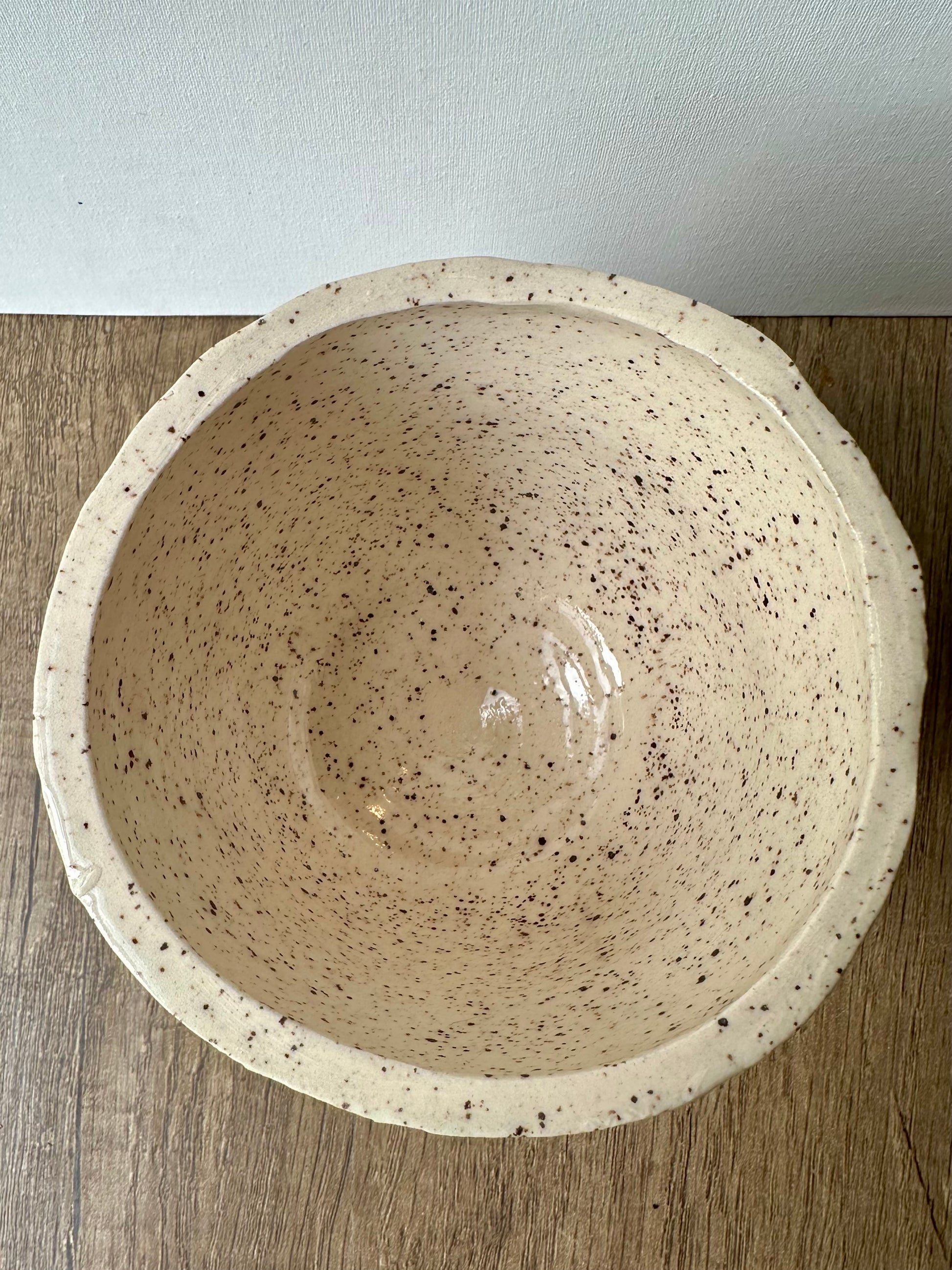 Interior of the vessel; white ceramic with black speckles, clear glossy finish.