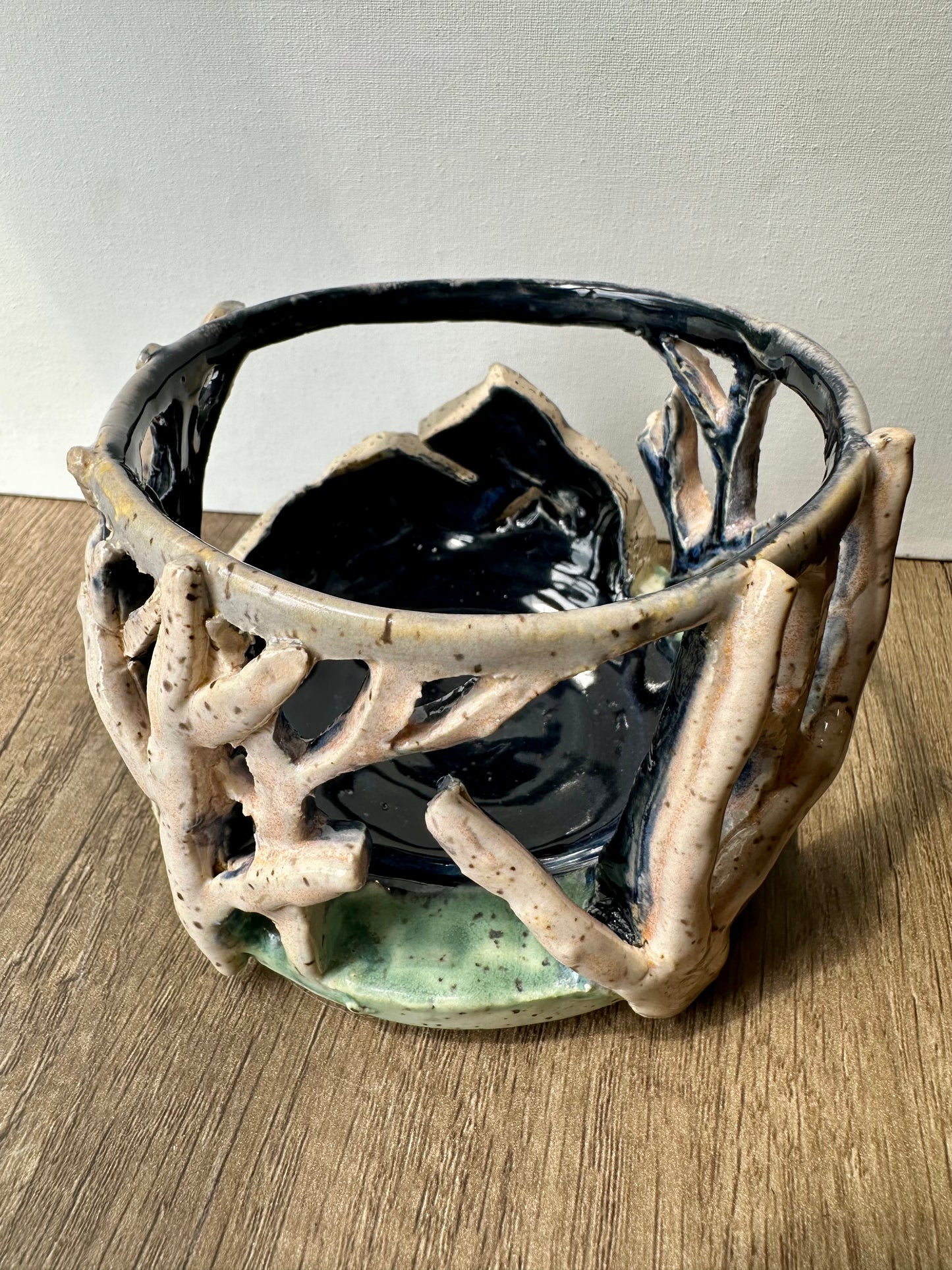 Round ceramic candle surround with mountain and birch trees cut out.