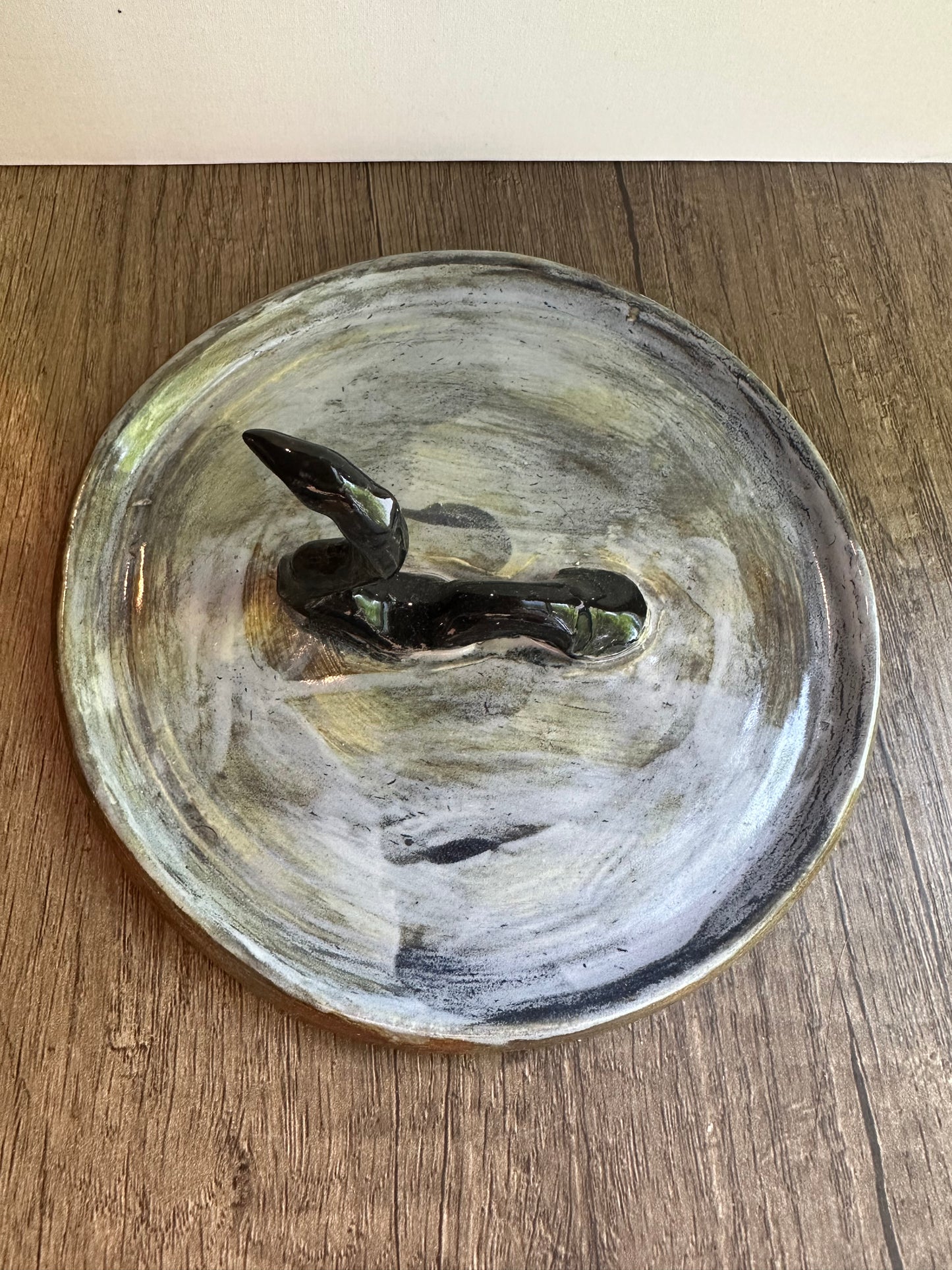 Loch Ness monster-inspired ring stand; black serpent in a pool of glossy, murky blue.