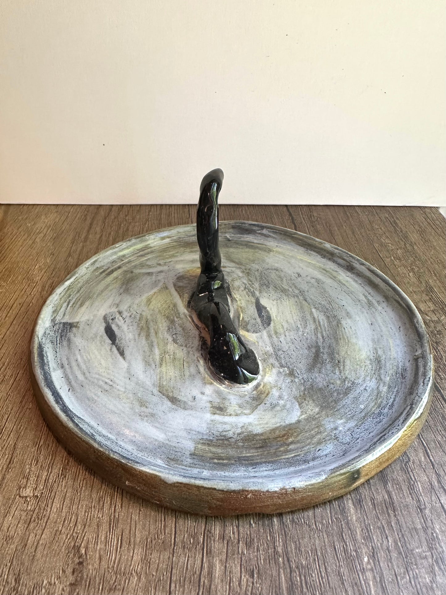 Loch Ness monster-inspired ring stand; black serpent in a pool of glossy, murky blue.