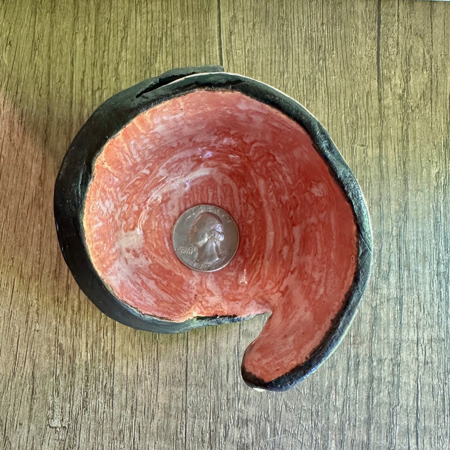 Overhead shot of peachy interior of multi-colored votive with a quarter inside for scale reference.