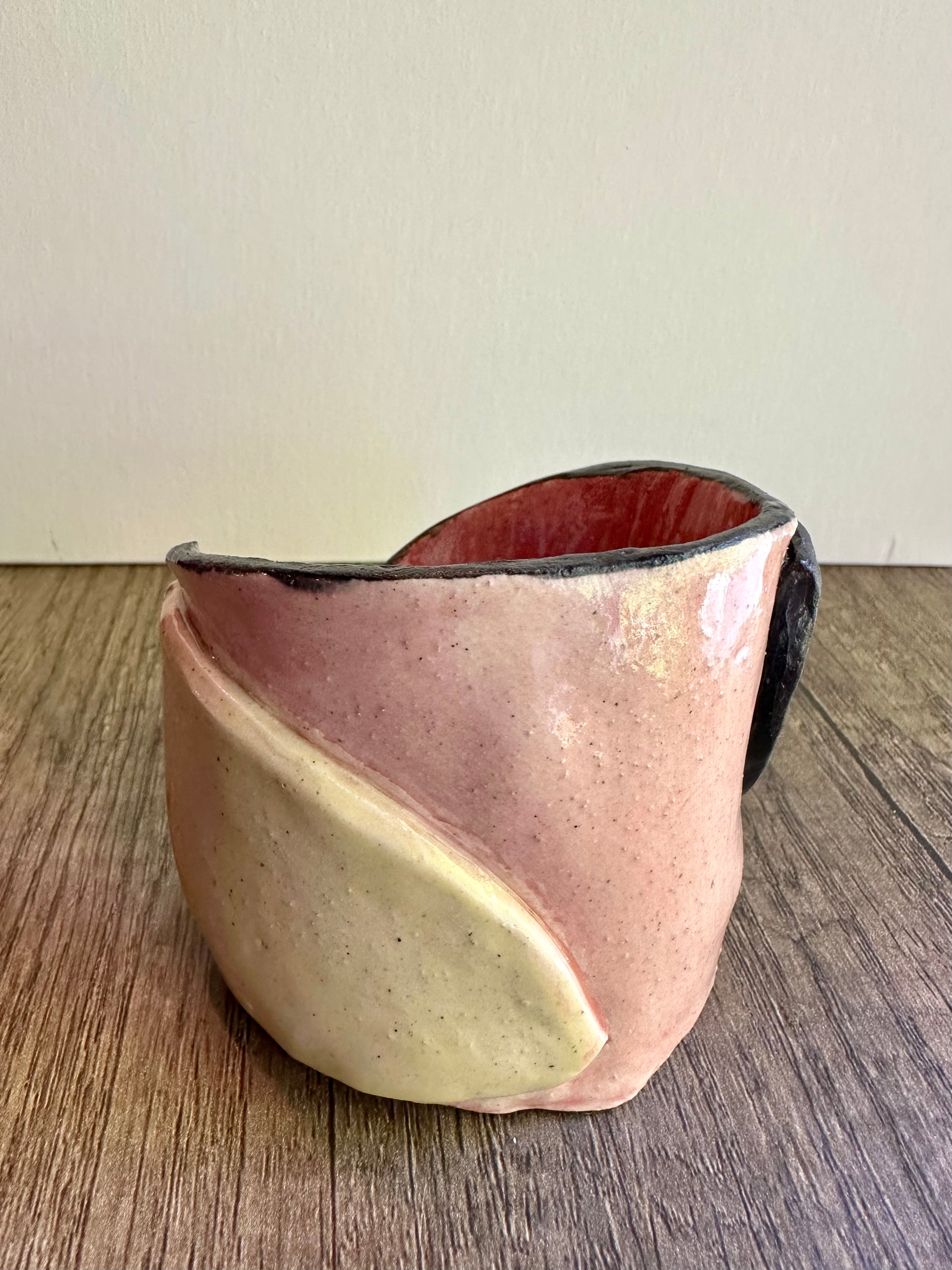 Back of ceramic multi-colored candle holder in neutral daylight.